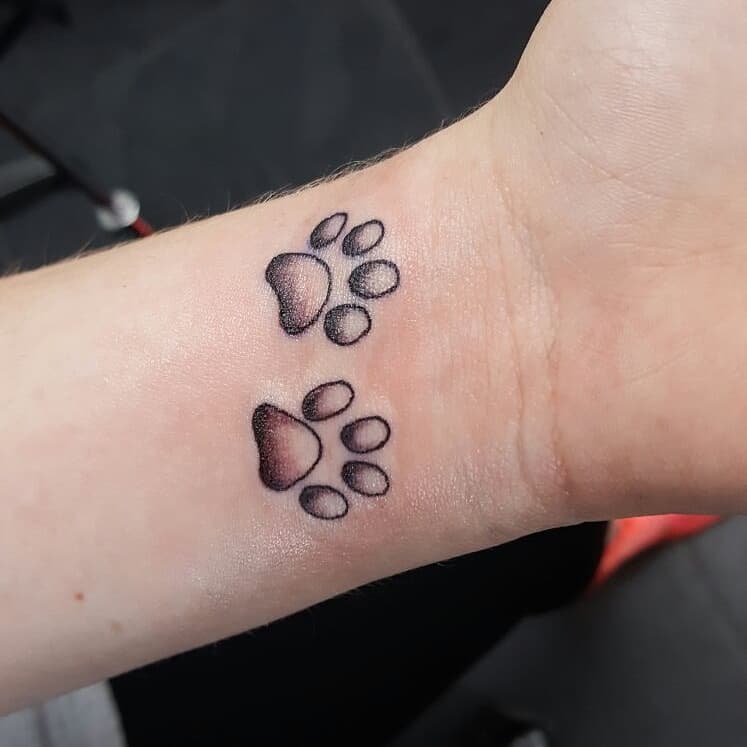 Twee kleine hondenpootjes op de pols.