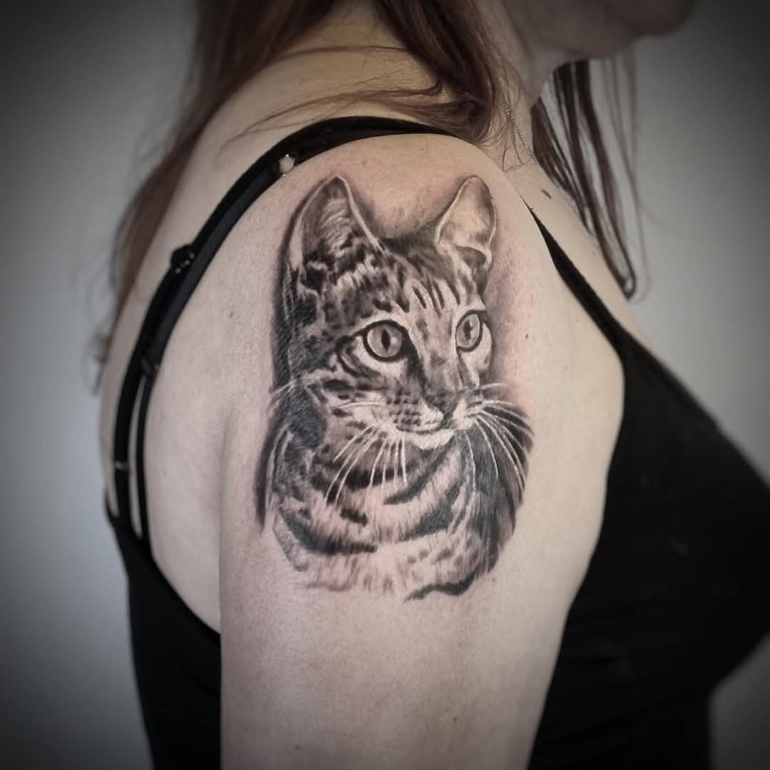 Realistisch portret van een cyperse kat op de bovenarm.