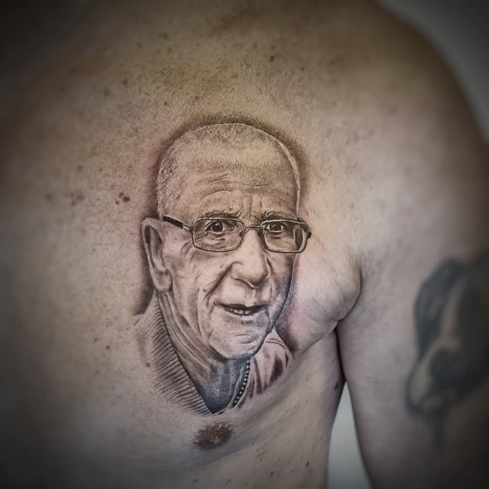 Realistisch portret van een oudere man met bril op de borst.