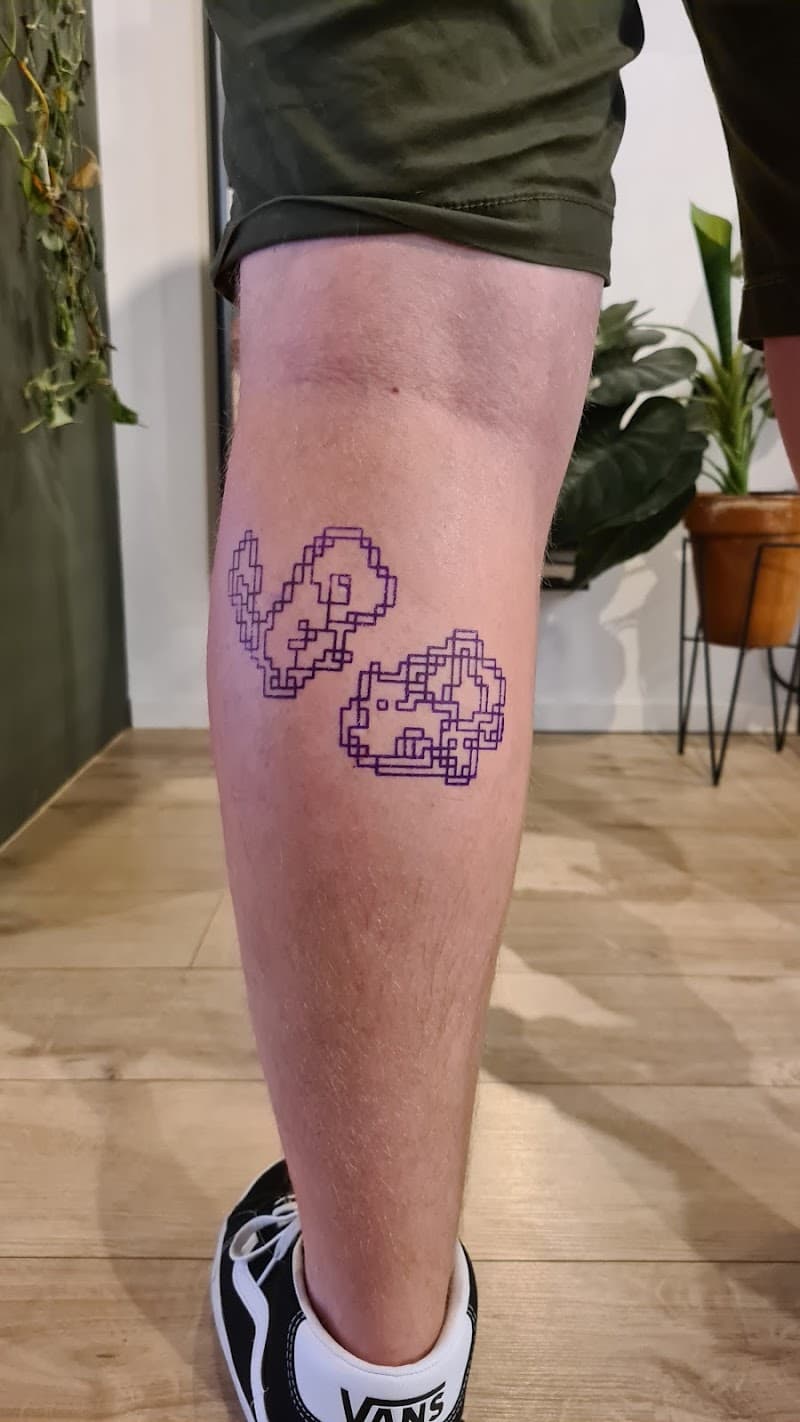 Twee paarse pixel art geometrische vormen op onderbeen