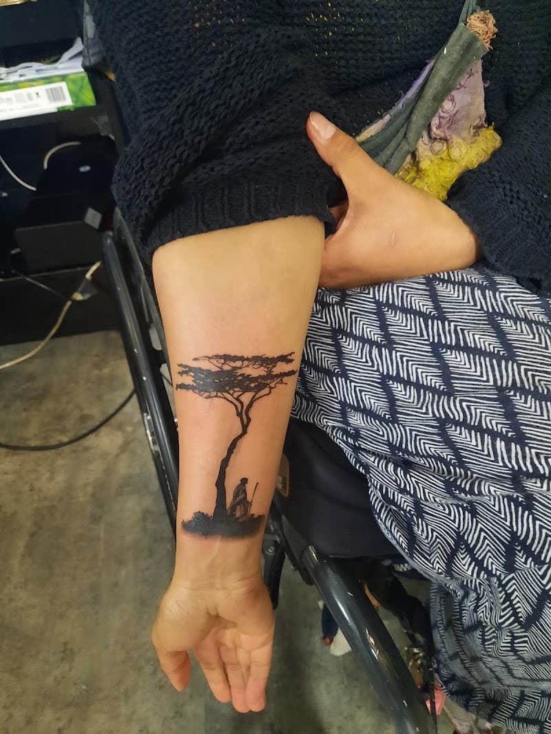 Zwart silhouet van een Afrikaanse boom met een persoon eronder op de onderarm.