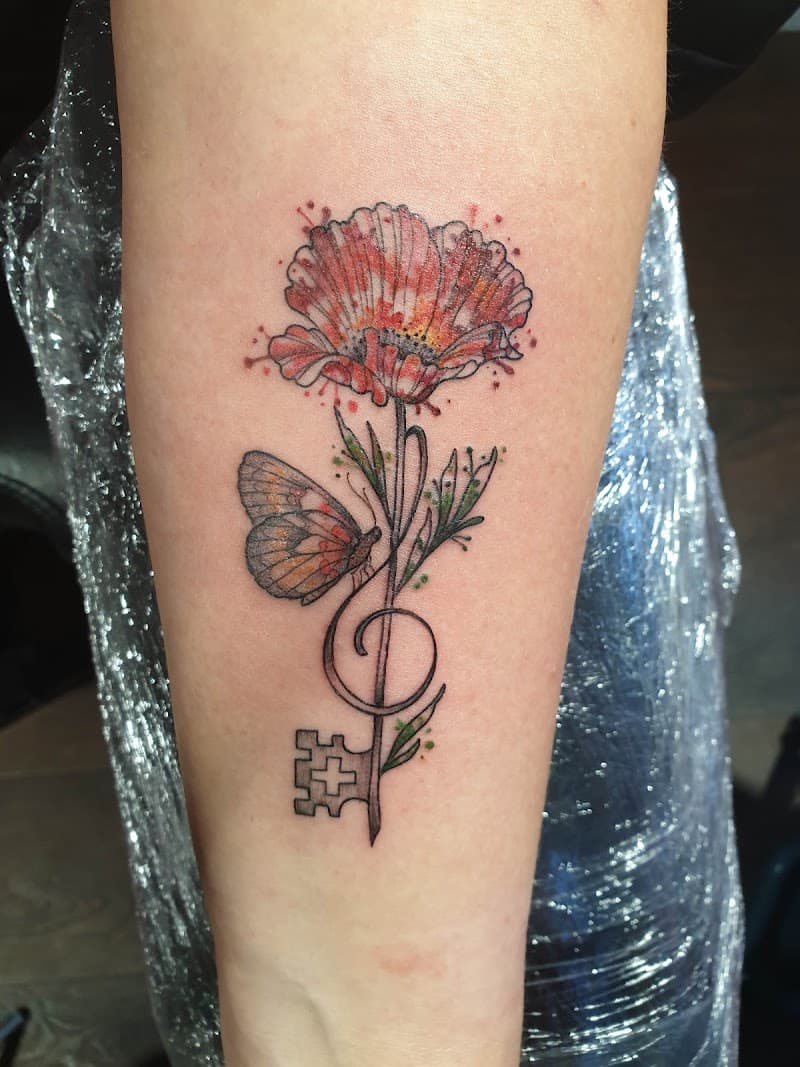 Watercolor klaproos met vlinder en muzieksleutel-sleutel op onderarm.