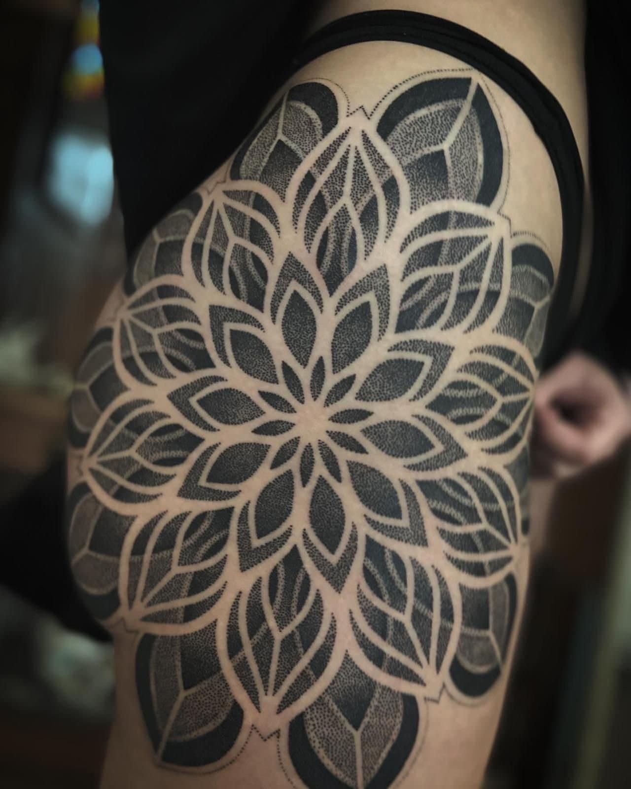 Grote dotwork mandala tattoo op de heup en bovenbeen.