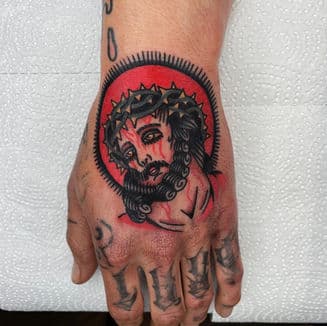 Traditionele tattoo van Jezus met doornenkroon op hand.
