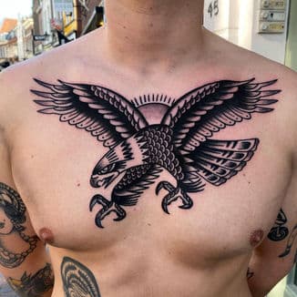 Traditionele adelaar tattoo op de borst, zwart-wit uitgevoerd.