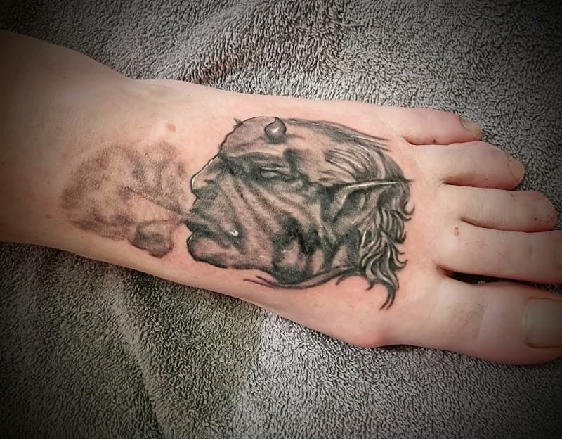 Zwart-wit portret van een rokende duivel op de voet.