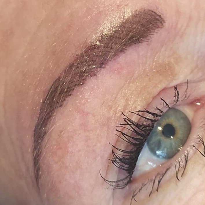 Permanente make-up wenkbrauw tattoo, close-up boven het oog.