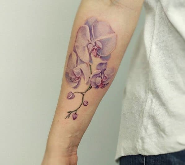 Realistische paarse orchideeën op de onderarm.