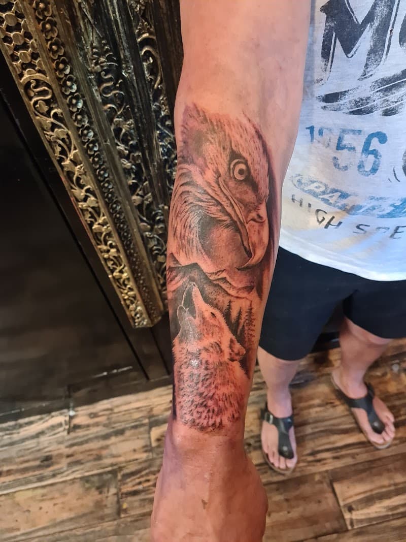 Realistische adelaar en huilende wolf in bos op onderarm.