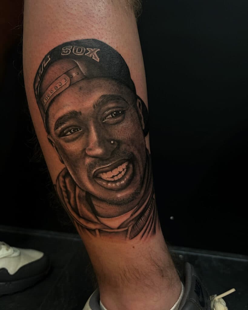 Realistisch portret van Tupac Shakur op onderbeen.