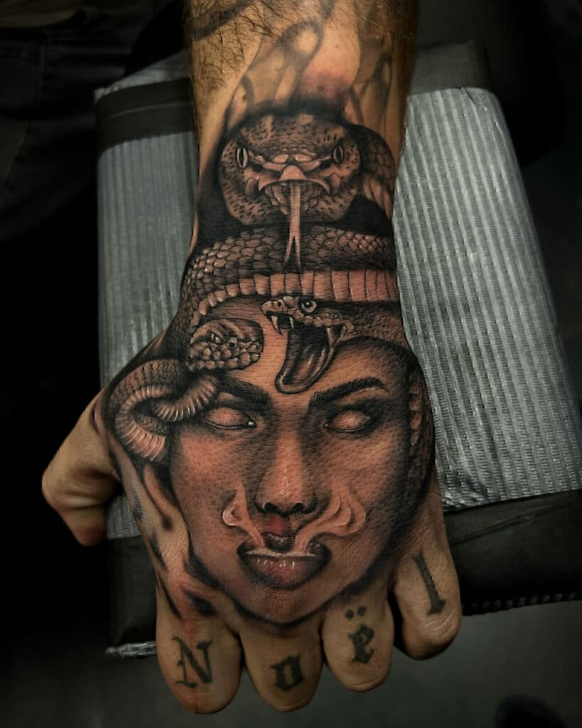 Realistische Medusa tattoo op hand met slangen en rook.