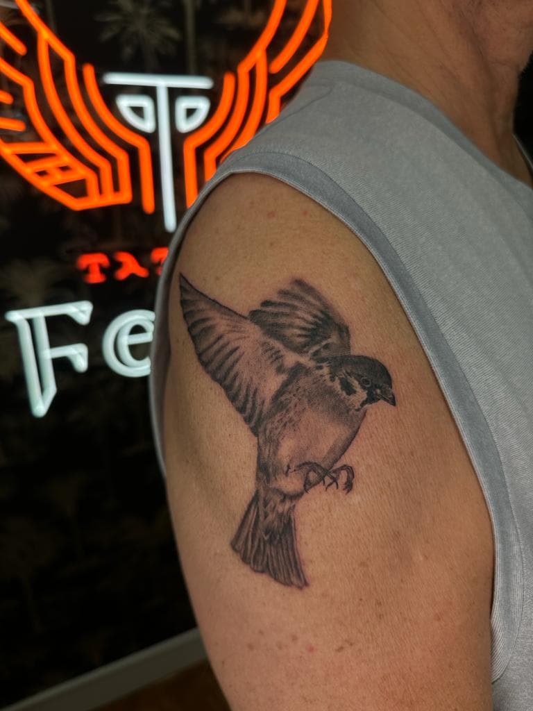 Realistische vliegende mus tattoo op bovenarm.