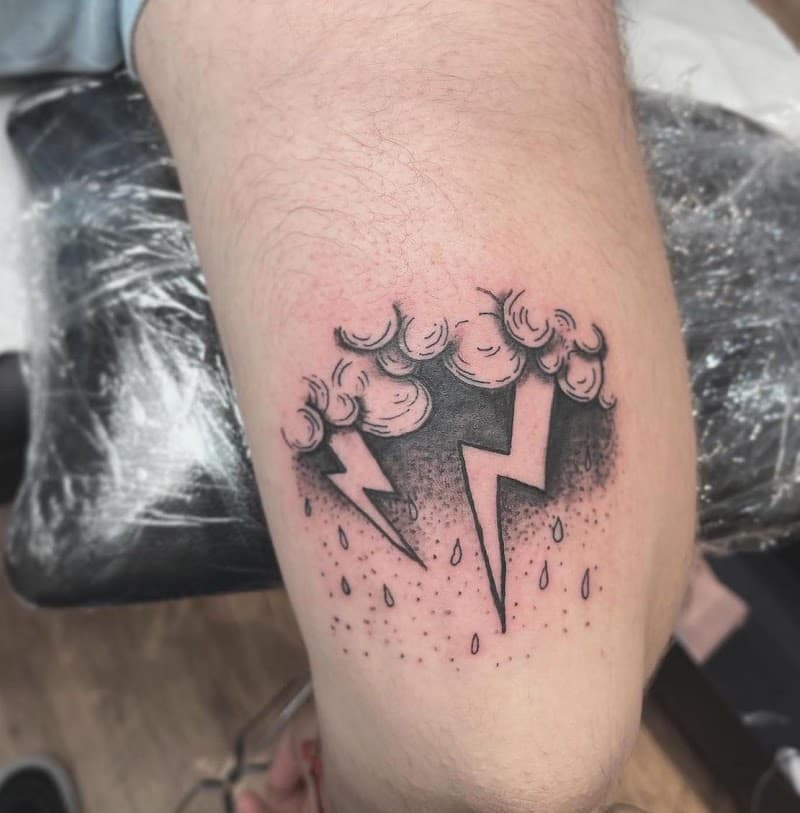 Zwart-wit tattoo van een onweerswolk met bliksem en regen.