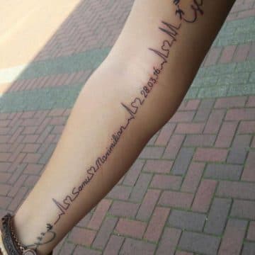Fineline hartslag tattoo met namen en datum op onderbeen.