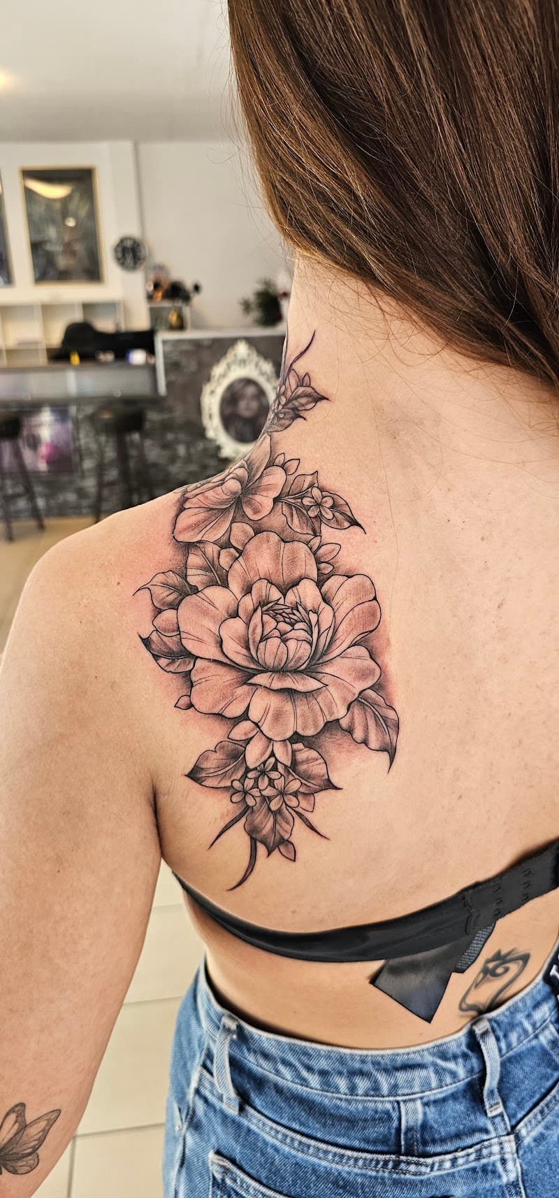 Grote zwart-wit bloementattoo op schouder en nek.