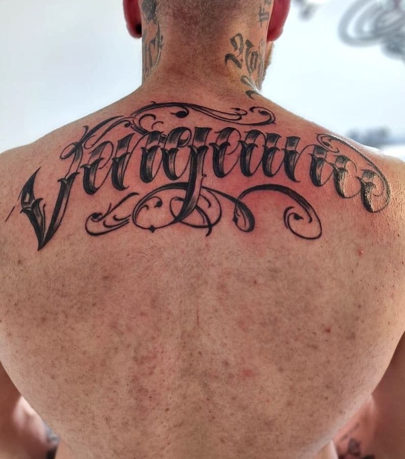 Grote sierlijke lettering tattoo op de bovenrug.