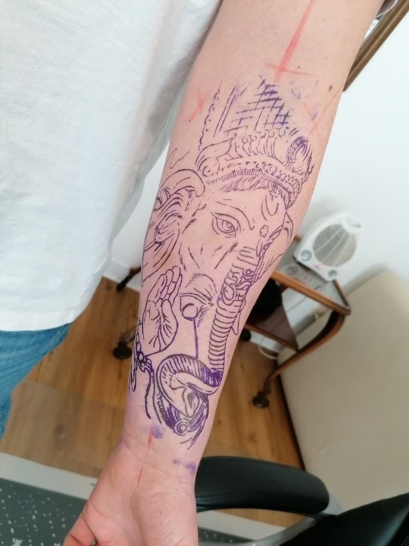 Paars stencil van Ganesha op onderarm.