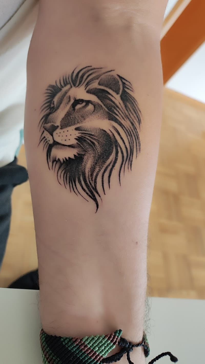 Zwart-wit leeuwenkop tattoo op de onderarm.