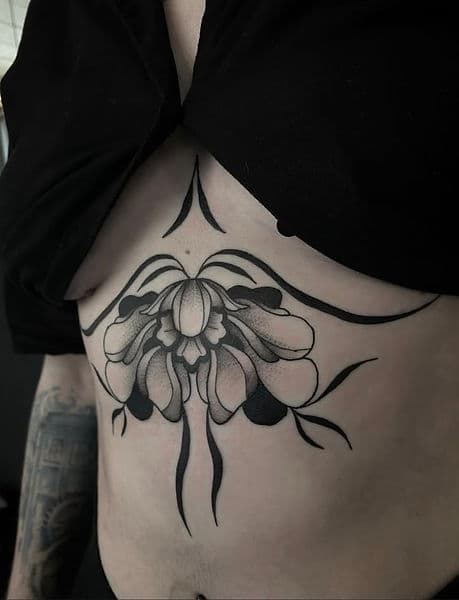 Symmetrische bloementattoo op de buik, blackwork stijl.