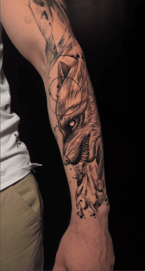 Gedetailleerde wolf tattoo met geometrische lijnen en dotwork op de onderarm.
