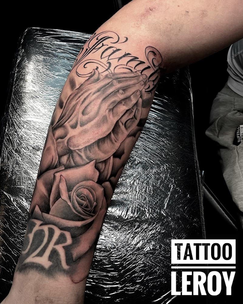Realistische biddende handen met roos en tekst op onderarm