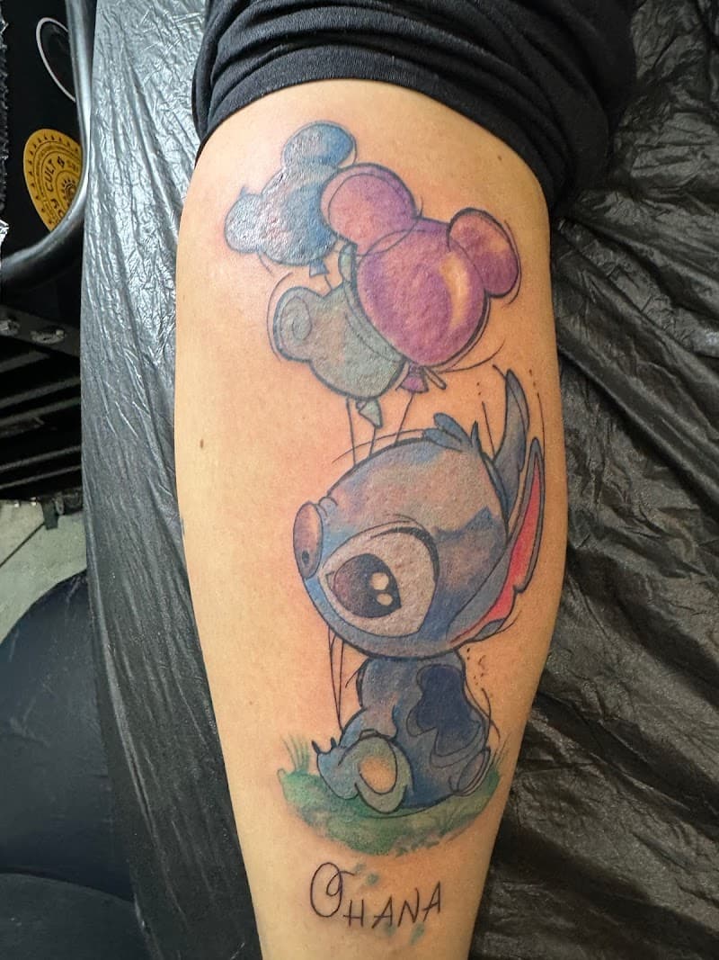 Watercolor tattoo van Stitch met Mickey ballonnen en 'Ohana' tekst.