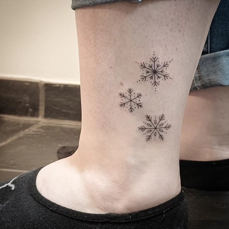 Drie minimalistische sneeuwvlokken op de enkel.