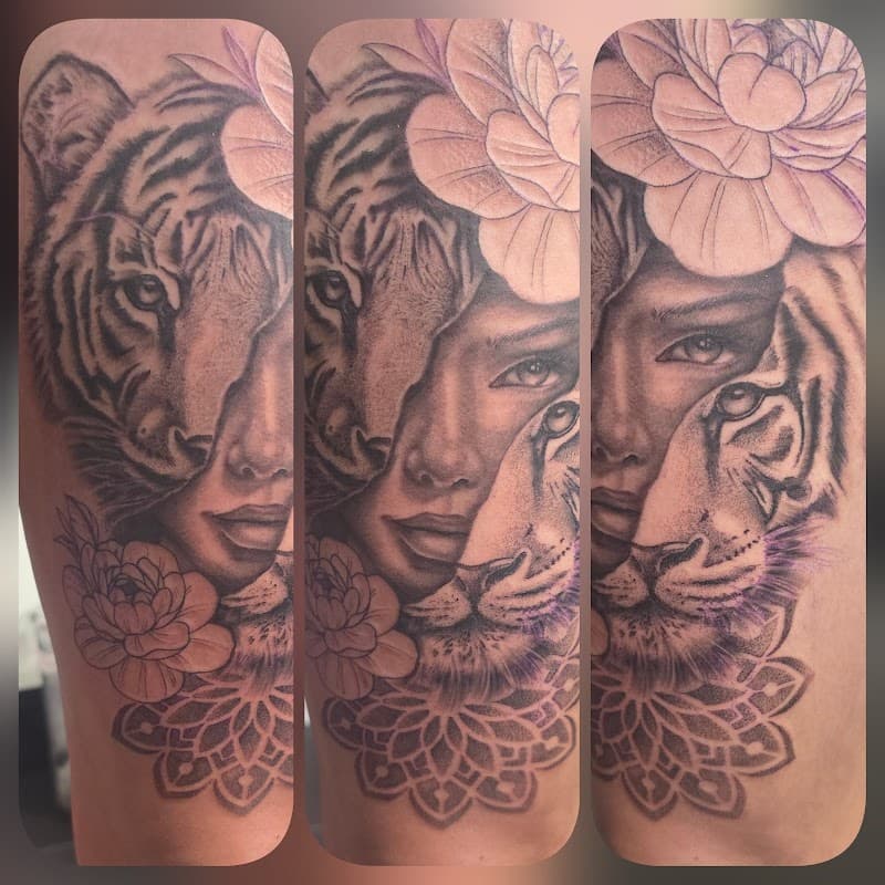 Realistisch portret van vrouw en tijger met bloemen en mandala op bovenbeen.