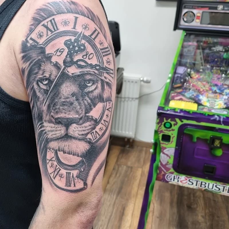 Zwart-wit tattoo van een leeuwenkop samengesmolten met een klok op de bovenarm.