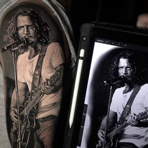 Realistisch portret van Chris Cornell met gitaar op bovenarm.
