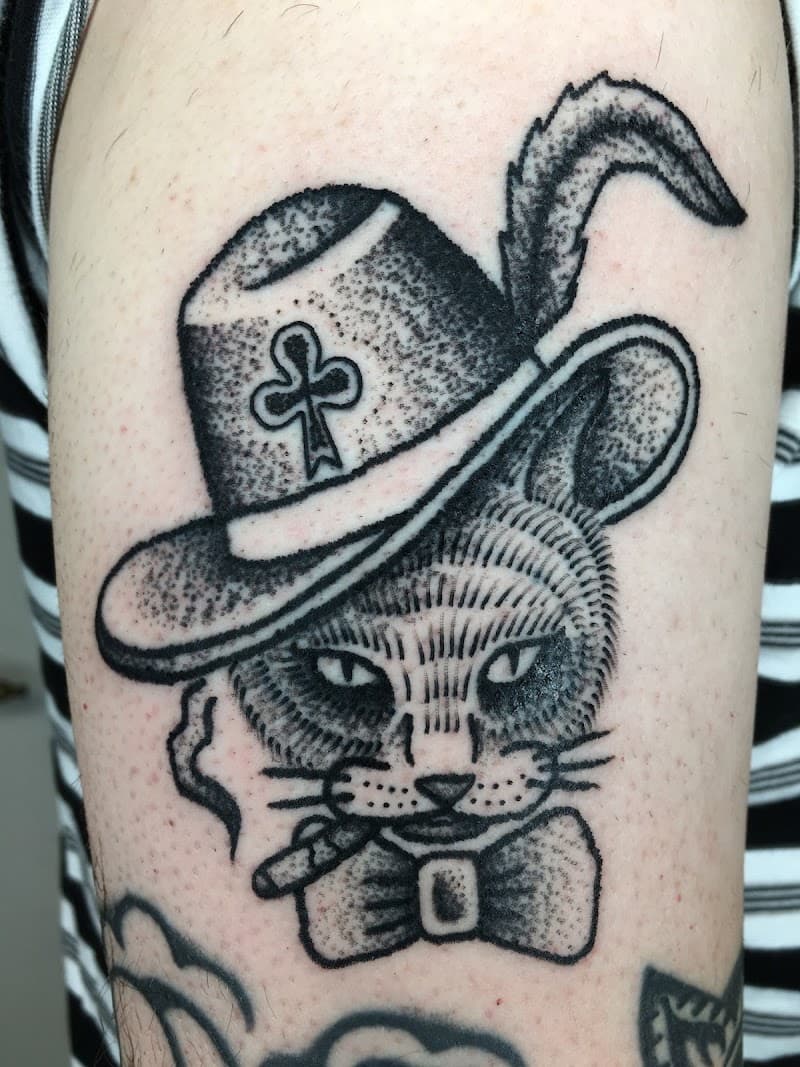 Zwart-wit tattoo van een kat met hoed, sigaar en strik.