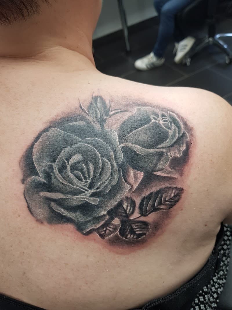 Zwart-grijze realistische rozen op schouderblad.