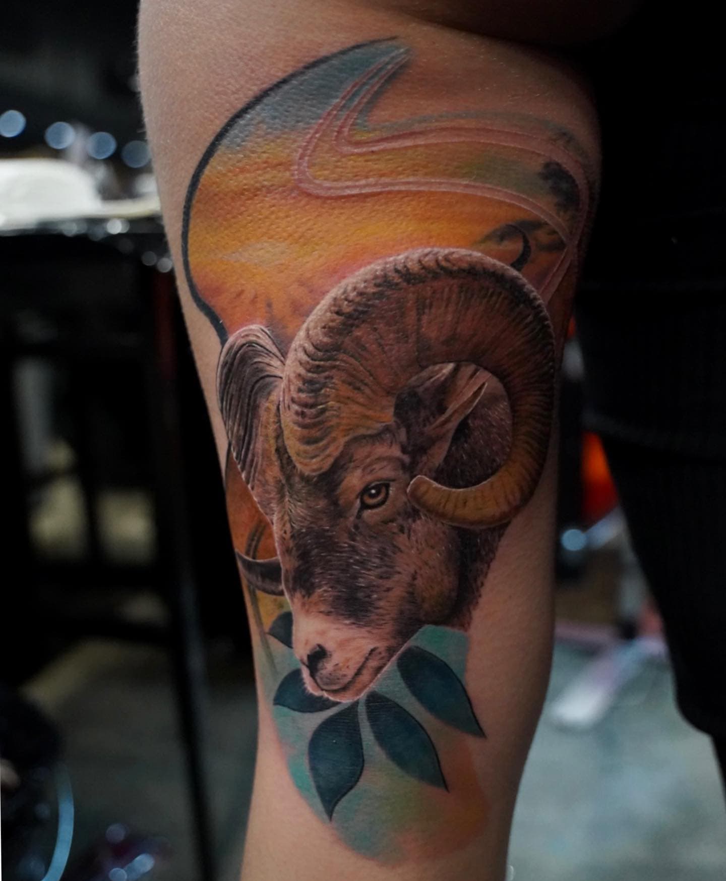 Realistische ram met gekleurde achtergrond op bovenbeen.