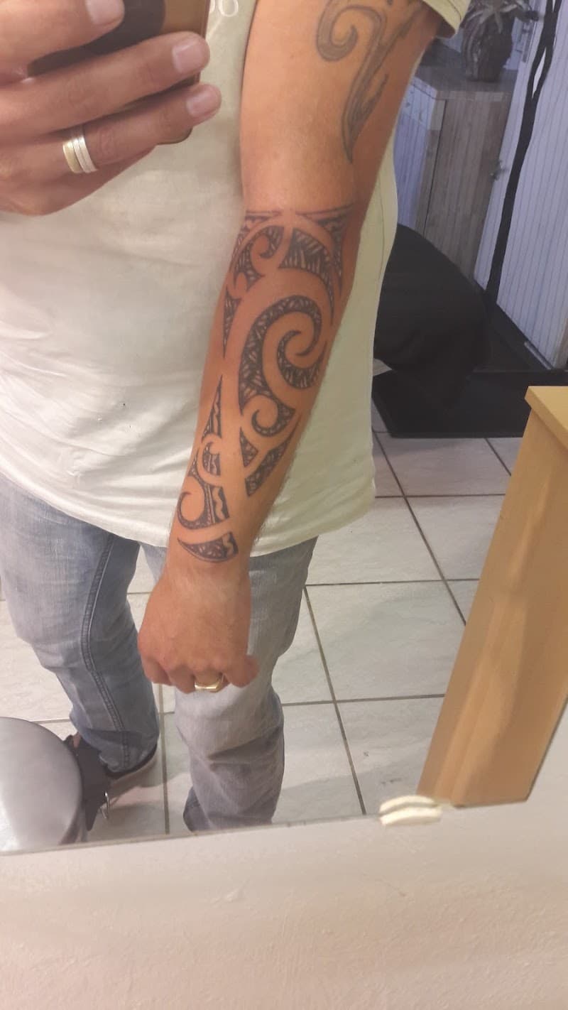 Zwart-wit tribal tattoo met spiraalpatronen op de onderarm.