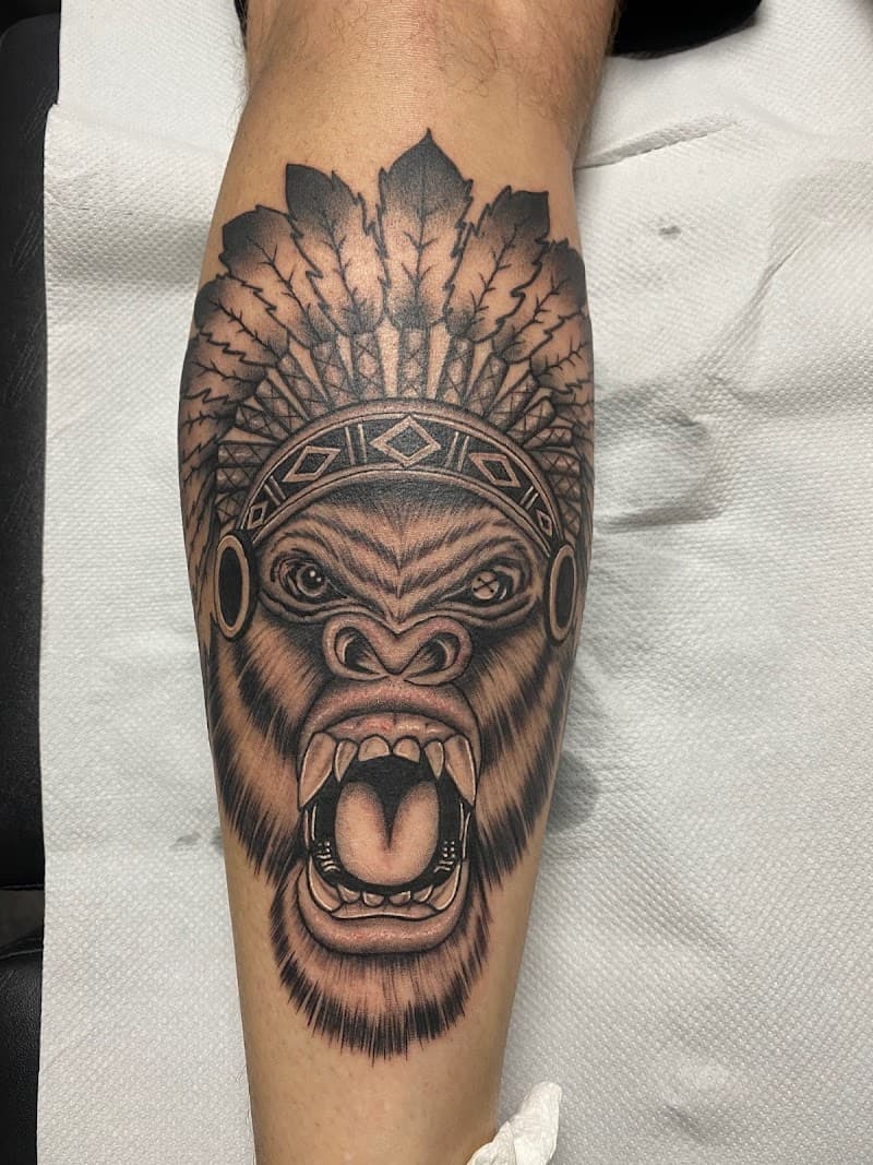 Realistische gorilla met indianentooi op onderbeen.