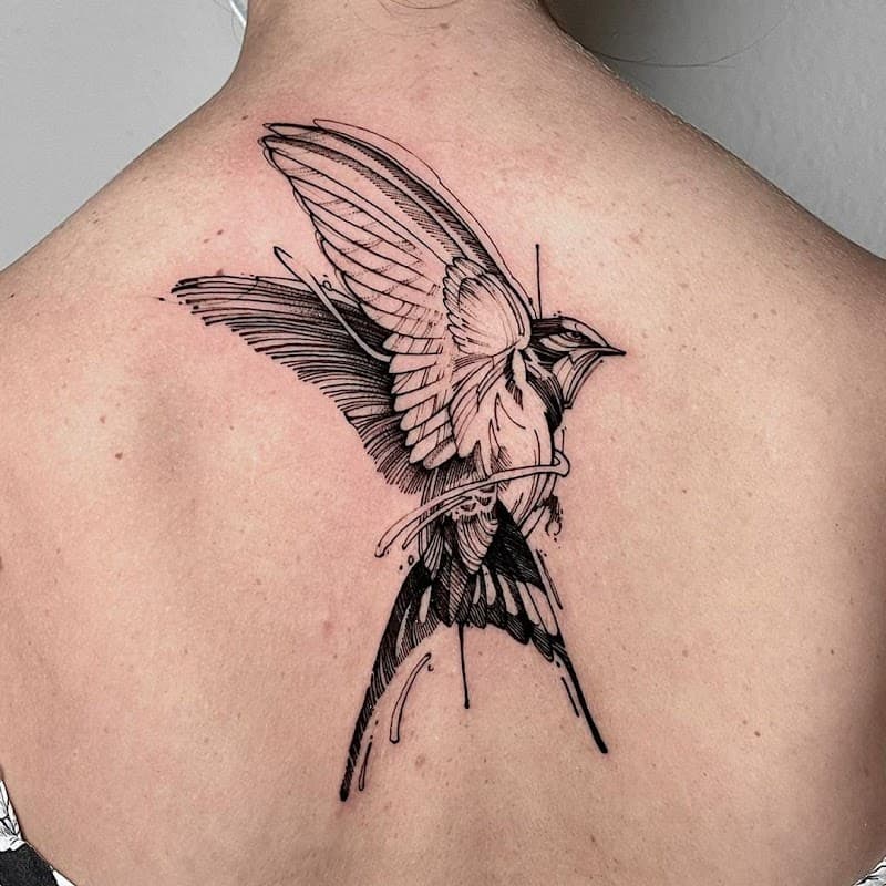 Zwart-wit zwaluw tattoo op de bovenrug in een illustratieve schetsstijl.