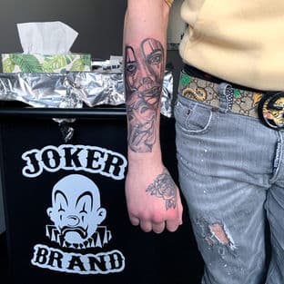 Chicano stijl portret op onderarm en een roos op de hand.