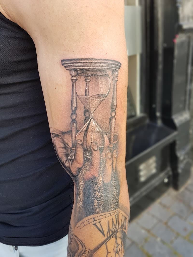 Realistische zandloper in handen op bovenarm.