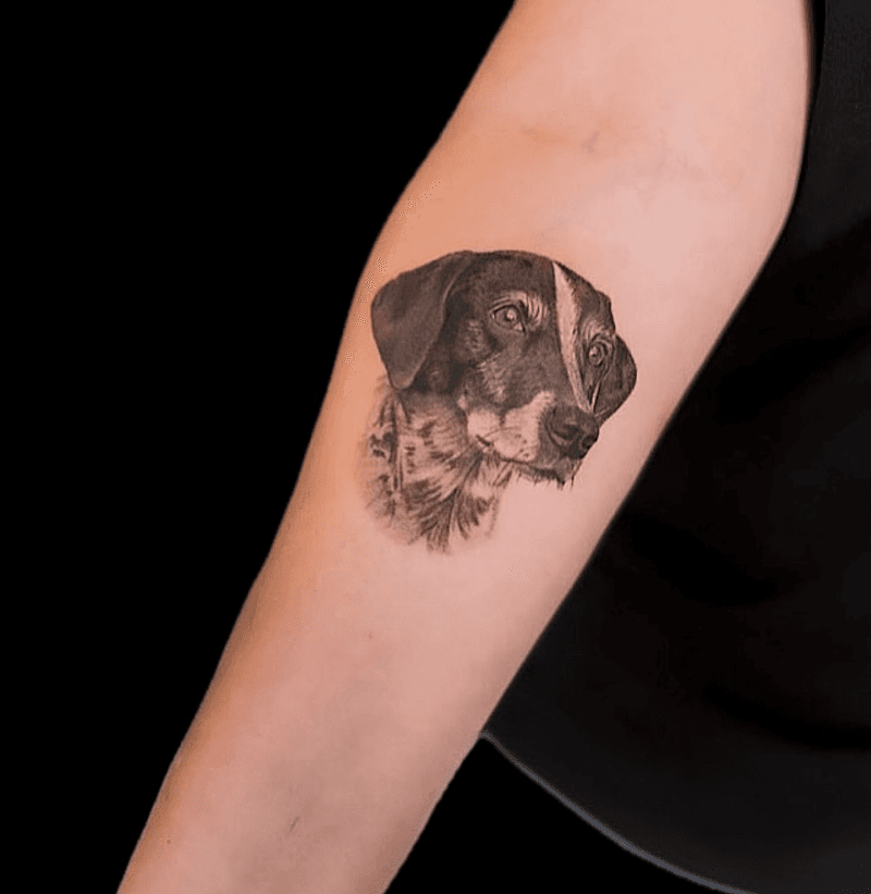 Realistisch portret van een hond op de bovenarm.