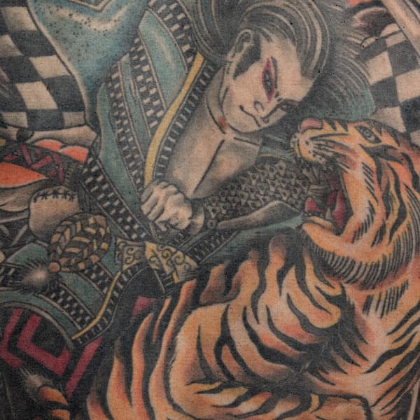 Japanse stijl tattoo van een samoerai die met een tijger vecht.