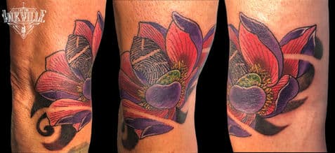 Kleurrijke neo-traditionele lotusbloem tattoo op het onderbeen.