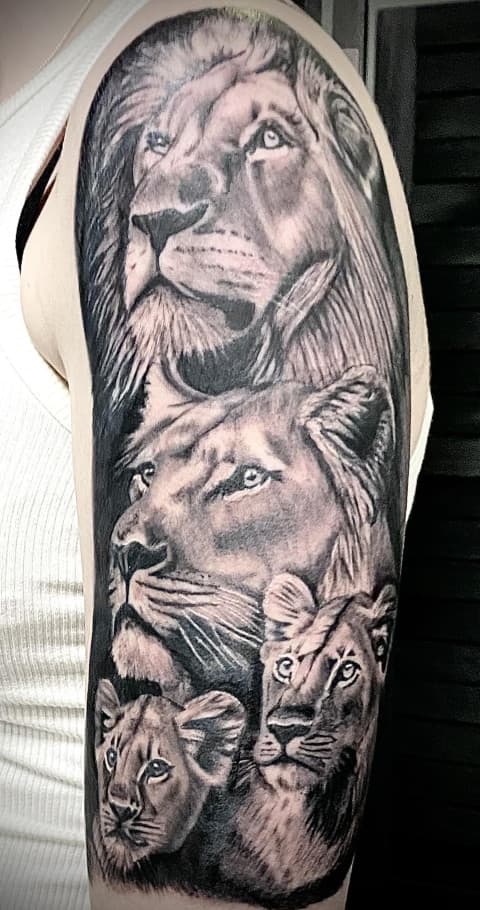 Realistische leeuwenfamilie tattoo op bovenarm.