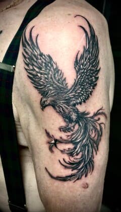 Zwart-wit feniks tattoo op de bovenarm.