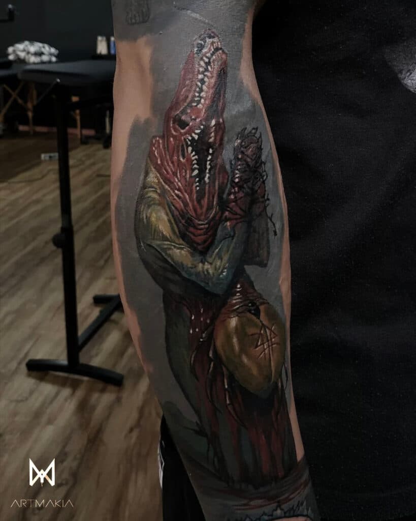 Duistere illustratieve tattoo van een krokodil-achtig wezen op de onderarm.