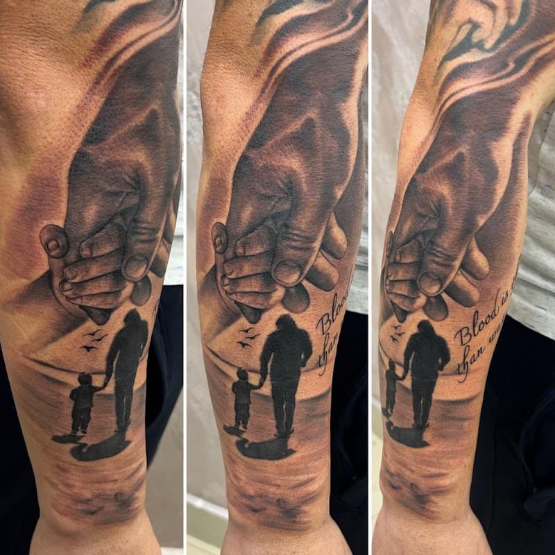 Zwart-wit tattoo van handen die elkaar vasthouden, met vader en kind silhouet.