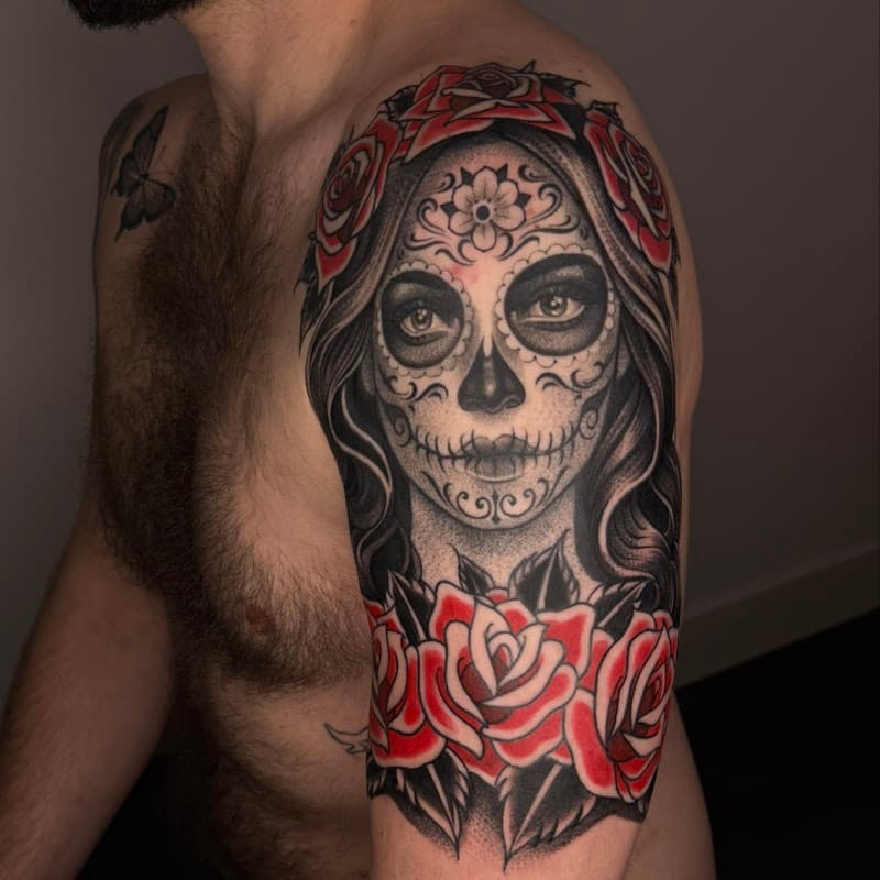 Grote Chicano tattoo van een vrouw met suikerschedel make-up en rode rozen.