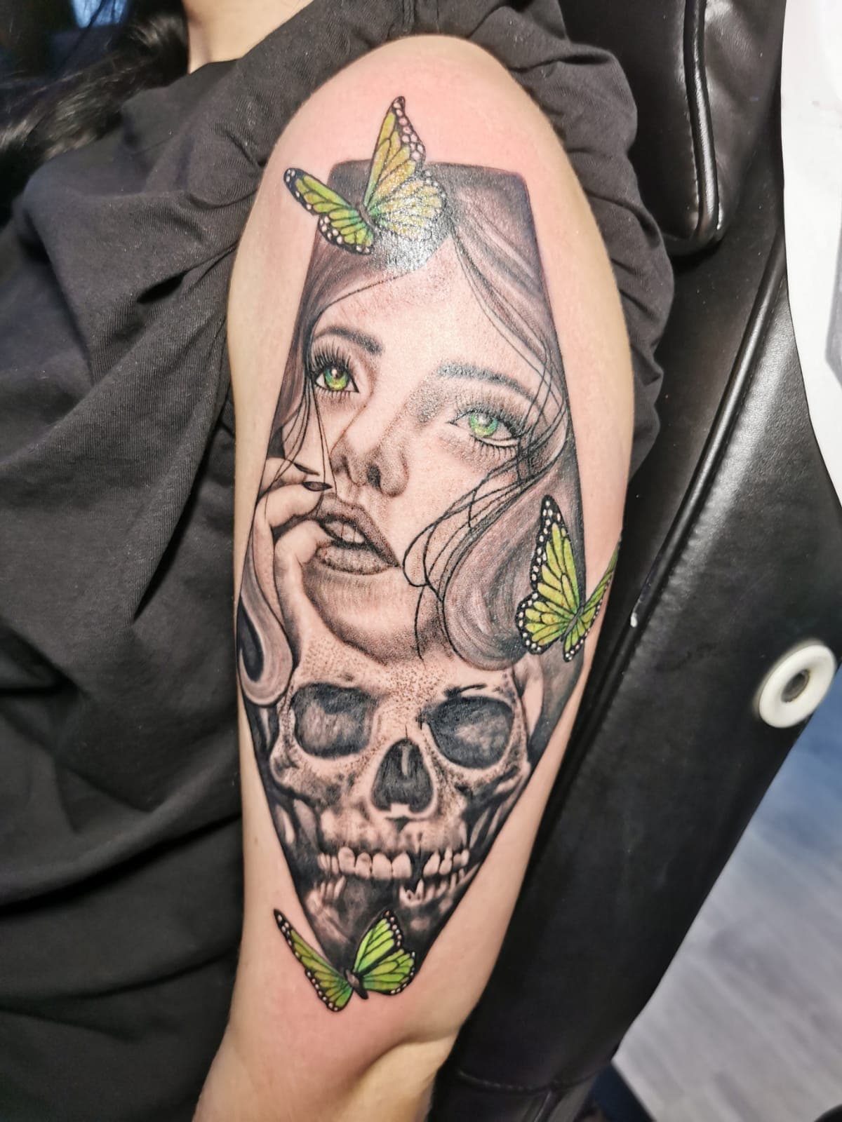 Realistisch portret van vrouw en schedel met groene vlinders.