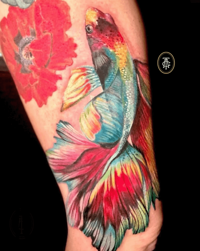 Kleurrijke betta vis en rode bloem op onderbeen.