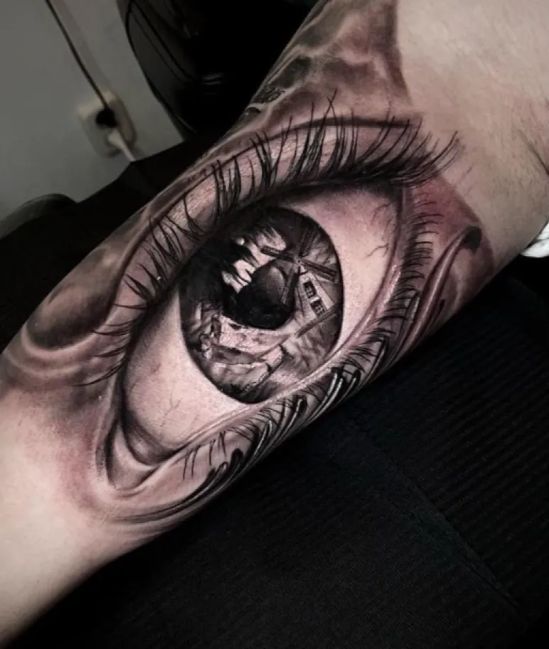 Realistisch oog met weerspiegeling van een molen in de pupil.