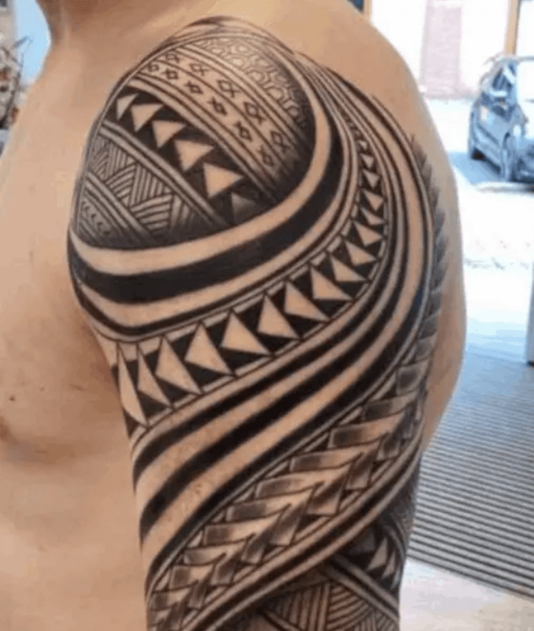 Grote Polynesische tribal tattoo op bovenarm en schouder.